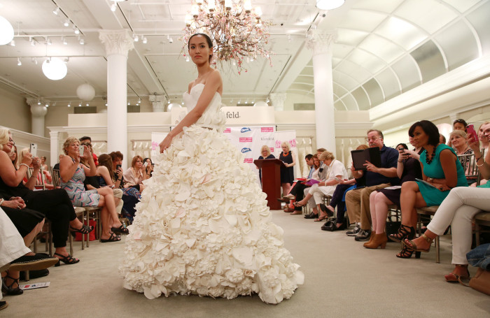 High-profile wedding planner and host of ÒMikie Saves the DateÓ, Michael Russo, poses with the winning dresses of the 11th Annual Toilet Paper Wedding Dress Contest presented by Cheap Chic Weddings and Charmin on Wednesday, June 17, 2015 in New York. (Amy Sussman/AP Images for Charmin)
